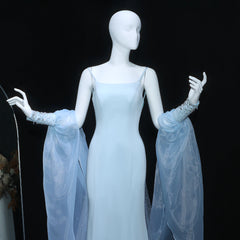 Mannequin wearing a light blue evening gown with sheer sleeves against a black background