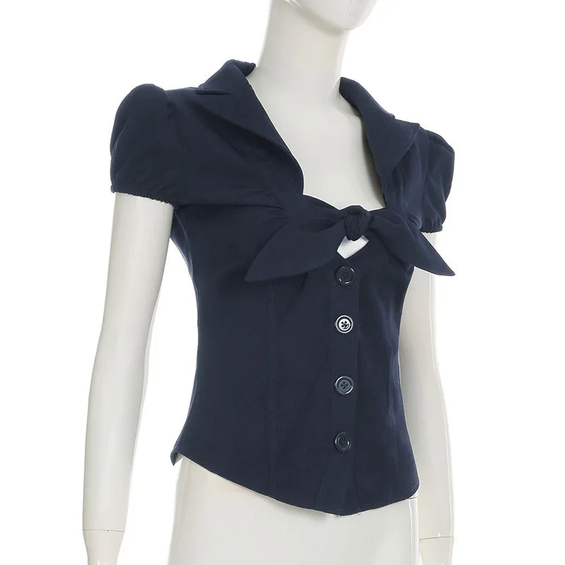Navy blue short-sleeve top with a bow detail on a mannequin against a white background
