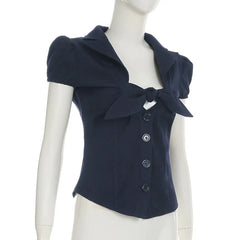 Navy blue short-sleeve top with a bow detail on a mannequin against a white background