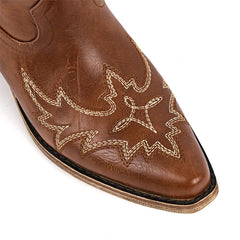Close-up of pointed toe on brown faux leather western boots with embroidery