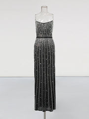 Black beaded evening gown on a mannequin against a white background