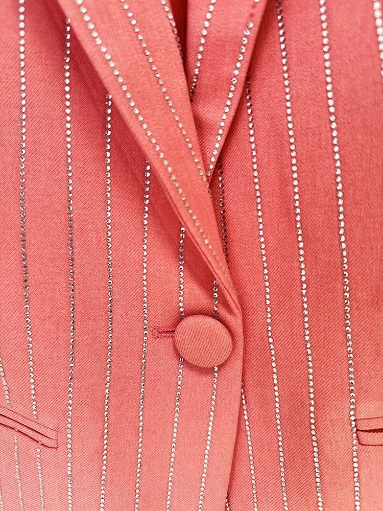 Close-up of a coral-colored blazer with pinstripes and a button.