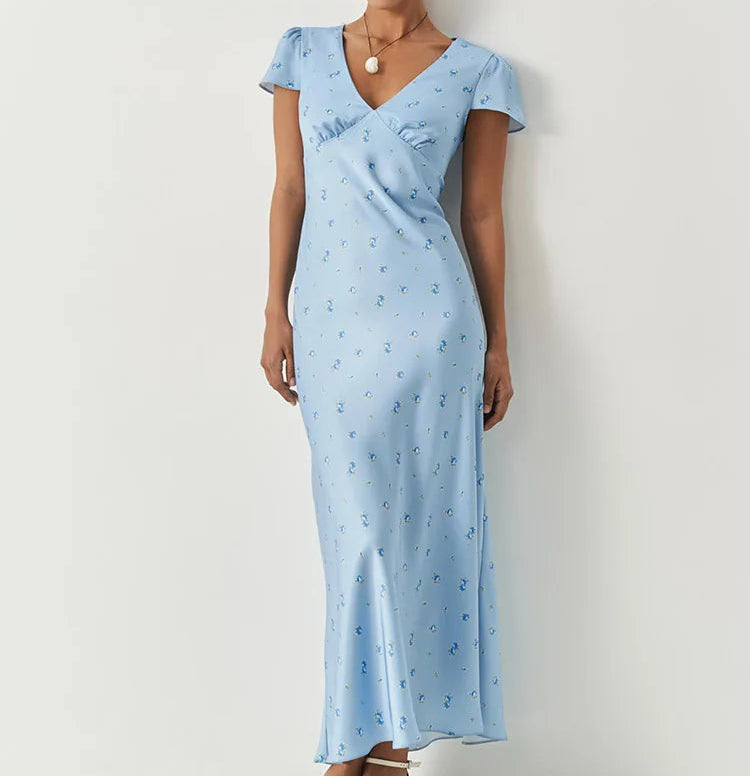 Woman wearing a light blue dress with a subtle pattern against a white background