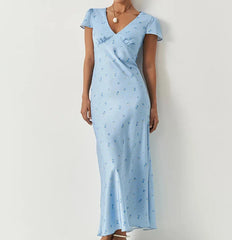 Woman wearing a light blue dress with a subtle pattern against a white background