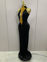 Black evening gown with gold embellishments on a mannequin against a plain background