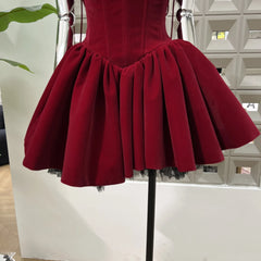 Red dress on a mannequin against a white wall.