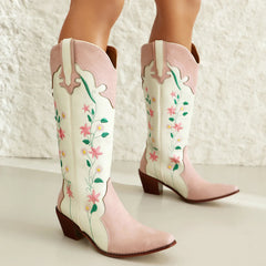 Pink and white cowboy boots with floral embroidery on a light background