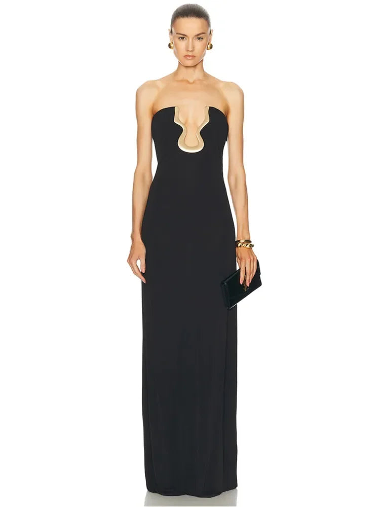 Model wearing a strapless black maxi dress with a gold neckline detail and clutch.