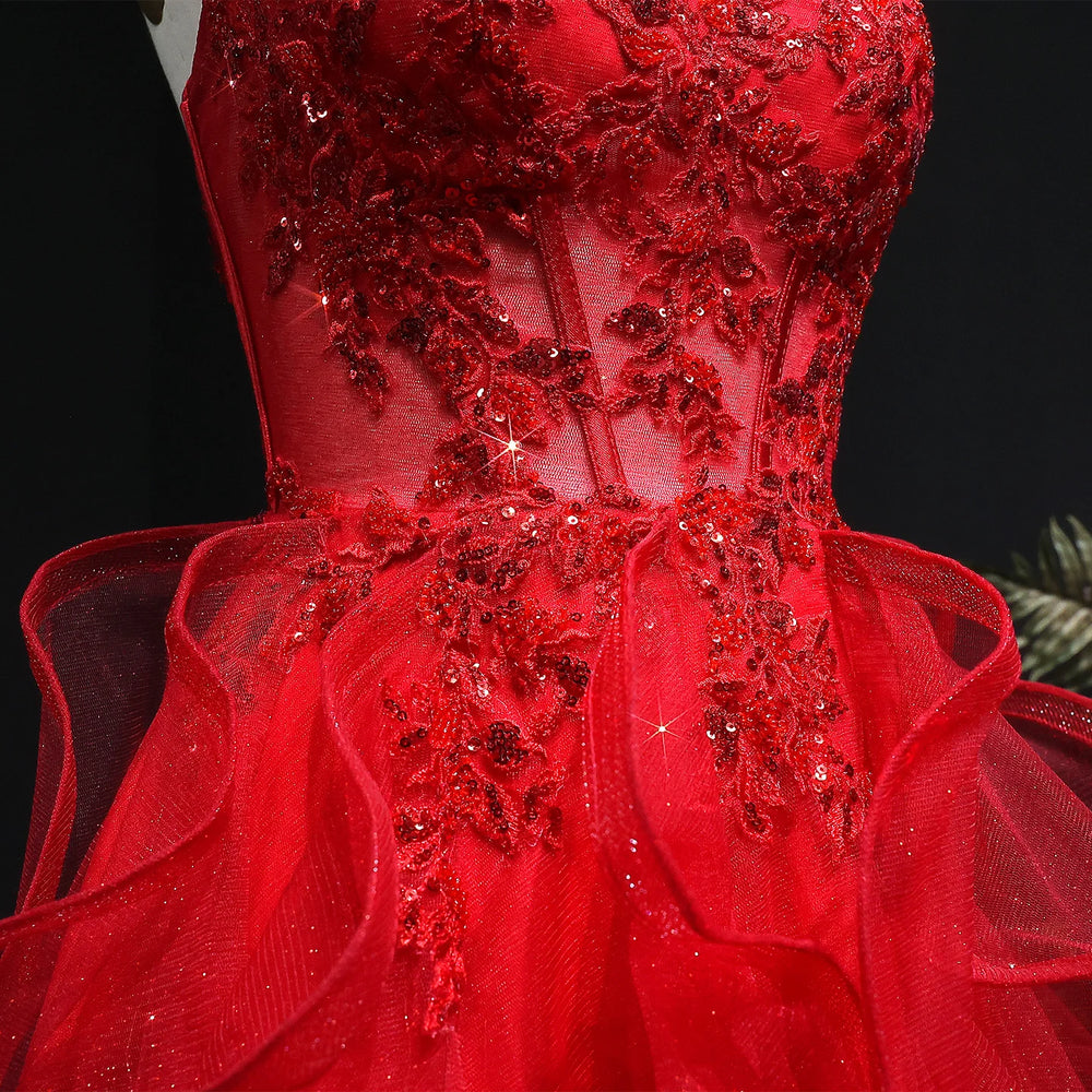 Red evening gown with intricate beadwork on a black background
