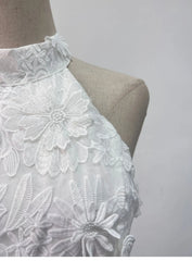 White lace top on a mannequin against a plain background