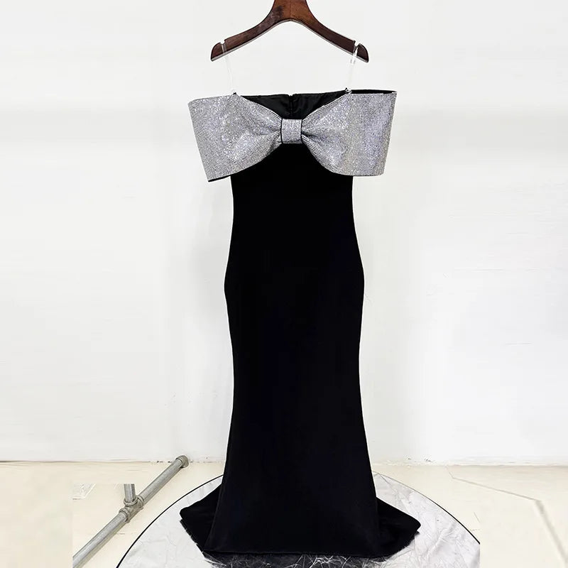 Black evening gown with a large silver bow on a white background