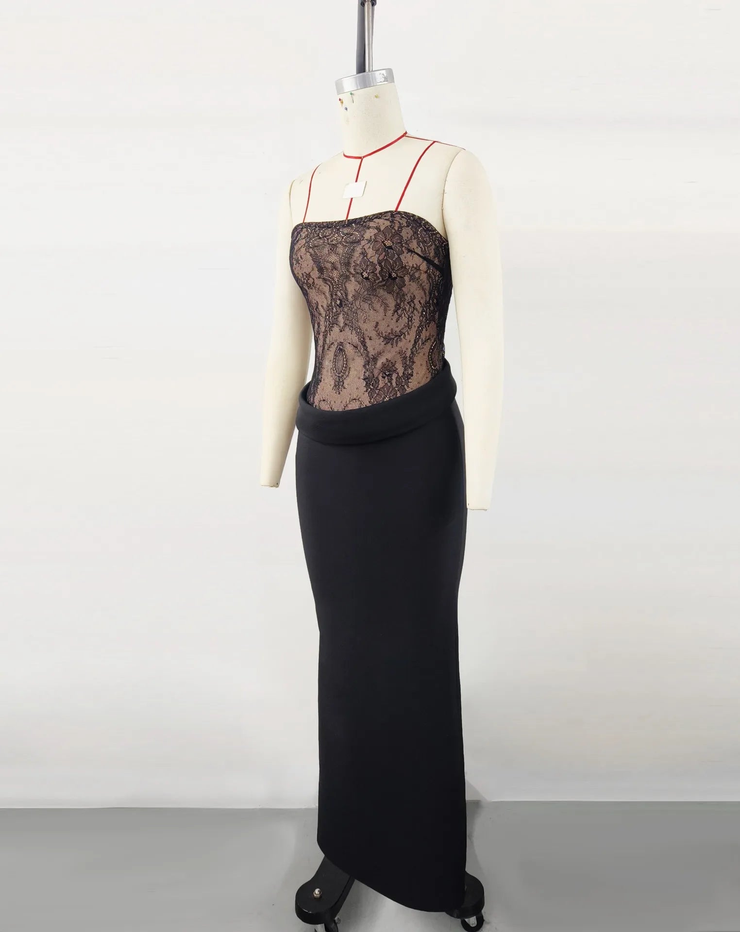 Black lace evening gown on a mannequin against a white background
