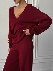 Maroon outfit worn by a person against a white wall