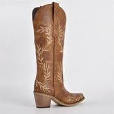 Brown cowboy boot with floral embroidery on a white background