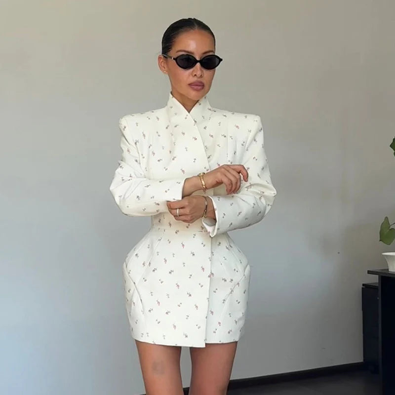 Woman wearing a white patterned outfit against a plain background