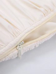 Close-up of a beige quilted cover with a zipper on a light gray background