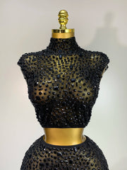 Black beaded top on a mannequin with a plain background
