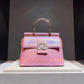 Pink ostrich embossed top handle bag with crystal clasp and textured handle.