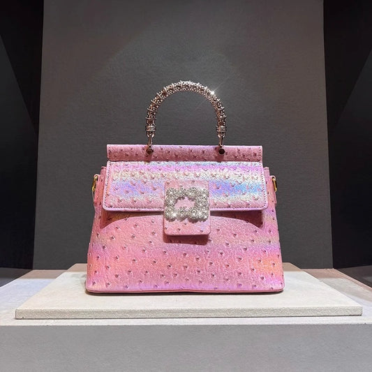Pink ostrich embossed top handle bag with crystal clasp and textured handle.