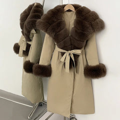 Beige coat with brown fur trim on a hanger against a white background