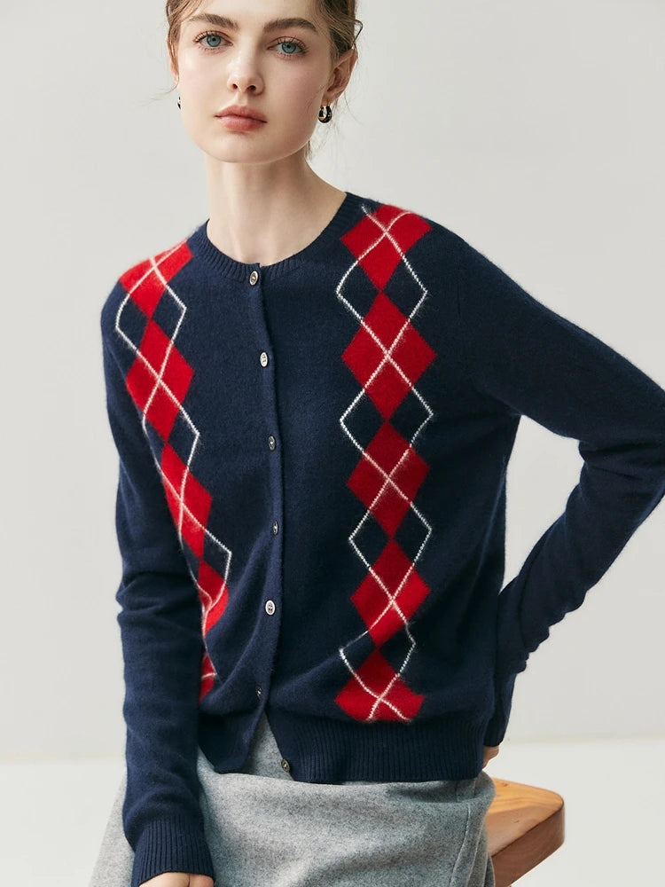 Person wearing a navy blue cardigan with red argyle pattern on a light gray background