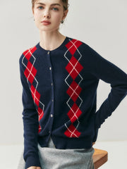 Person wearing a navy blue cardigan with red argyle pattern on a light gray background