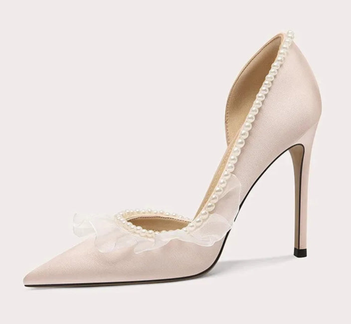 Beige high-heeled shoe with lace details on a light gray background