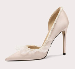 Beige high-heeled shoe with lace details on a light gray background