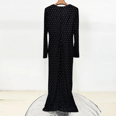 Black beaded polka dot maxi dress on a hanger, showing the back detail.