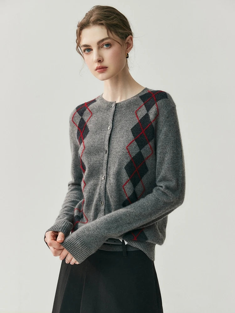 Woman wearing a gray cardigan with red and black diamond pattern on a light gray background