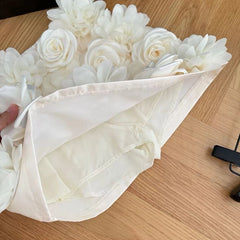 White flowers wrapped in a white cloth on a wooden surface