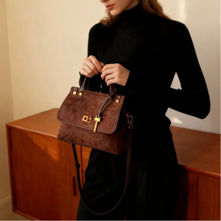 Woman holding a brown handbag in a room with wooden furniture.