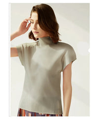 Woman wearing a light gray top with a plain background