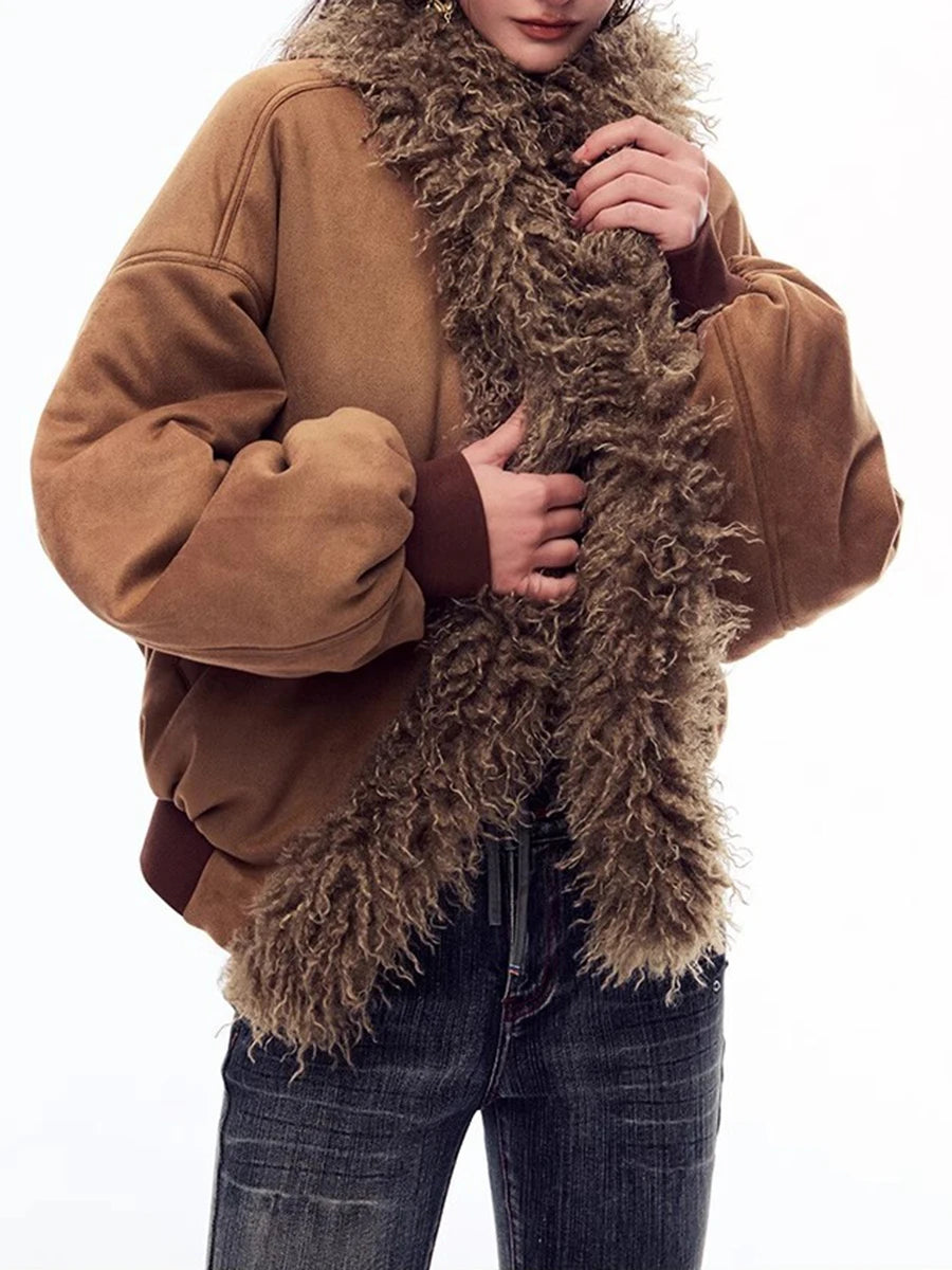 Person wearing a brown jacket and holding a large brown fur scarf