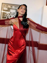 Woman in a red dress with sheer sleeves in an indoor setting