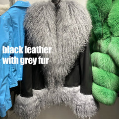 Black leather jacket with gray fur trim displayed on a rack with green fur jacket in the background.