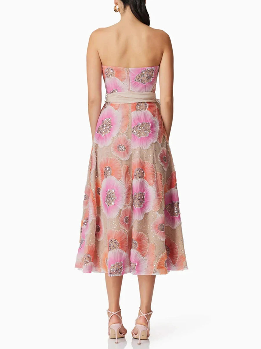 Woman wearing a strapless floral dress with pink and orange flowers on a white background