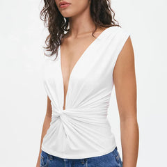 White sleeveless top with a deep neckline and knot detail worn by a person on a white background