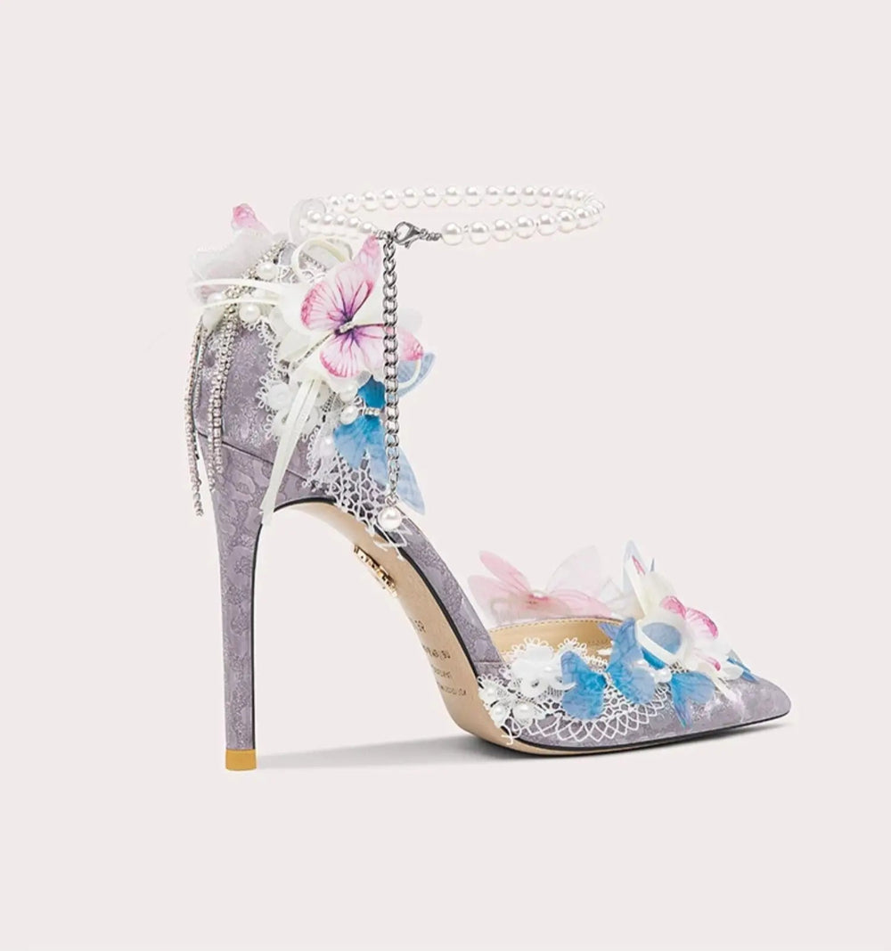 High-heeled shoe with floral and butterfly design on a light pink background
