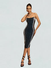 Woman wearing a black strapless dress with silver sequins on a light gray background