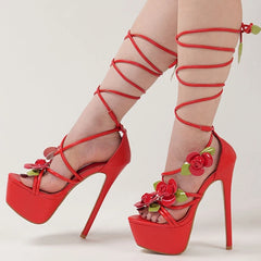 Red high-heeled shoes with floral decorations on a light gray background