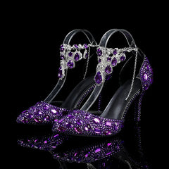 Purple high-heeled shoes with gemstone embellishments on a black background