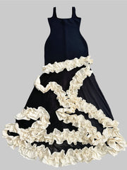 Black dress with white ruffled skirt on a gray background