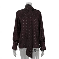 Brown blouse with white polka dot pattern on a mannequin against a white background