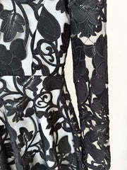 Close-up of a black floral lace fabric on a white background