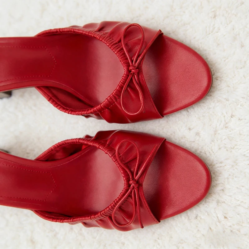 Top down view of red bow detail stiletto heel slides