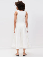 Woman wearing a white dress on a plain background