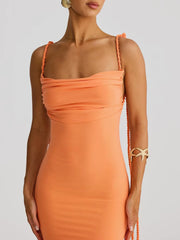 Orange dress with thin straps on a plain background