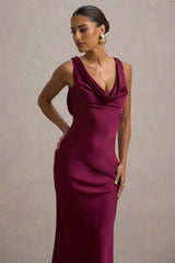 Woman wearing a burgundy evening gown against a neutral background