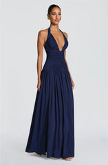 Navy blue halter neck gown on a model against a light gray background